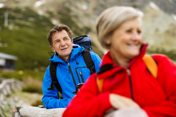 Beautiful senior couple of tourists in the mountains together, spring time.