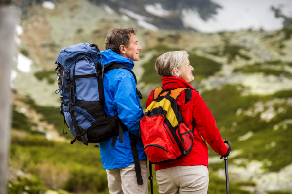 Beautiful senior couple of tourists in the mountains together, spring time.