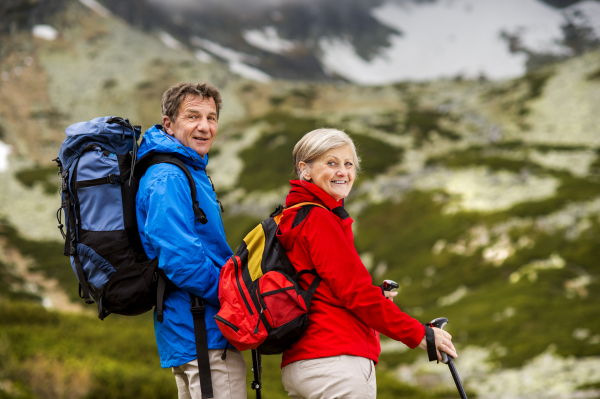 Beautiful senior couple of tourists in the mountains together, spring time.