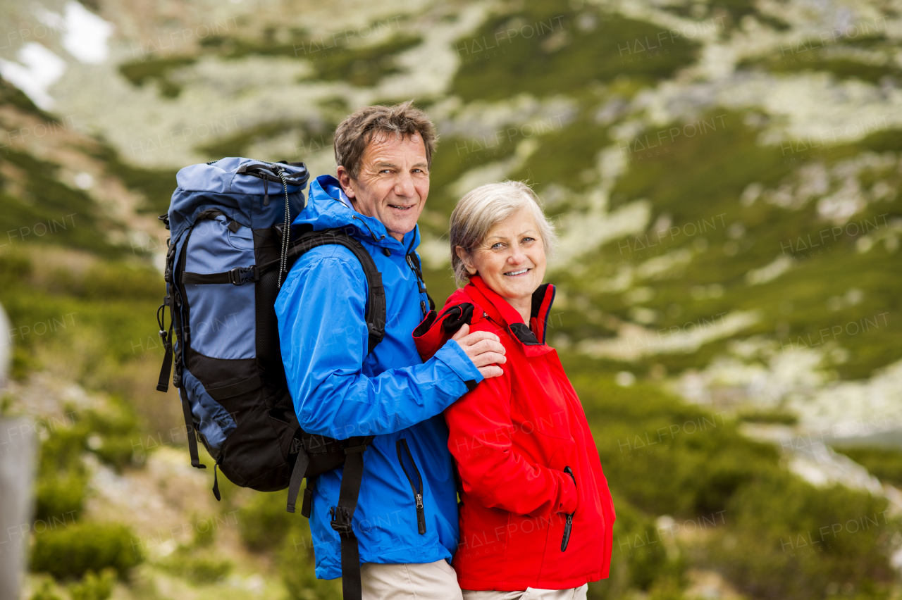 Beautiful senior couple of tourists in the mountains together, spring time.