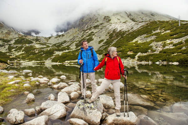 Beautiful senior couple of tourists in the mountains together, spring time.