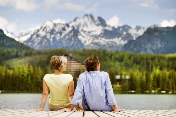 Beautiful senior couple of tourists in the mountains together, spring time.