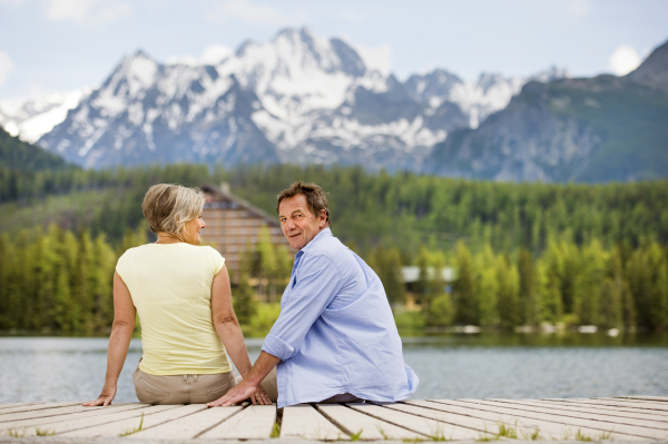 Beautiful senior couple of tourists in the mountains together, spring time.