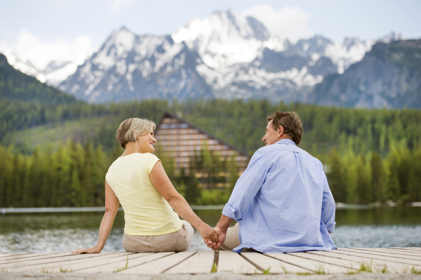 Beautiful senior couple of tourists in the mountains together, spring time.