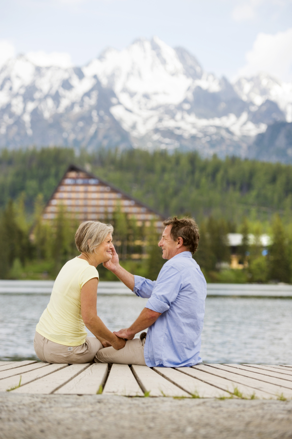 Beautiful senior couple of tourists in the mountains together, spring time.