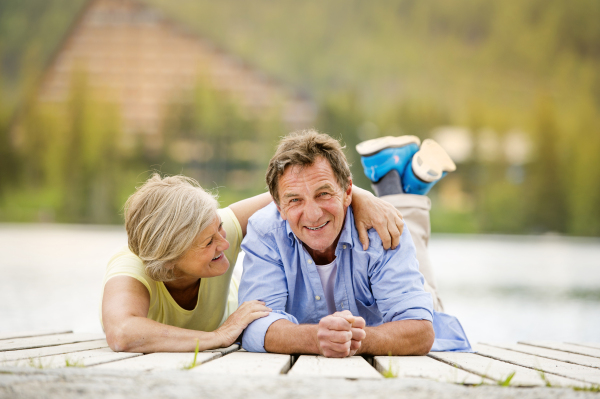 Beautiful senior couple of tourists in the mountains together, spring time.