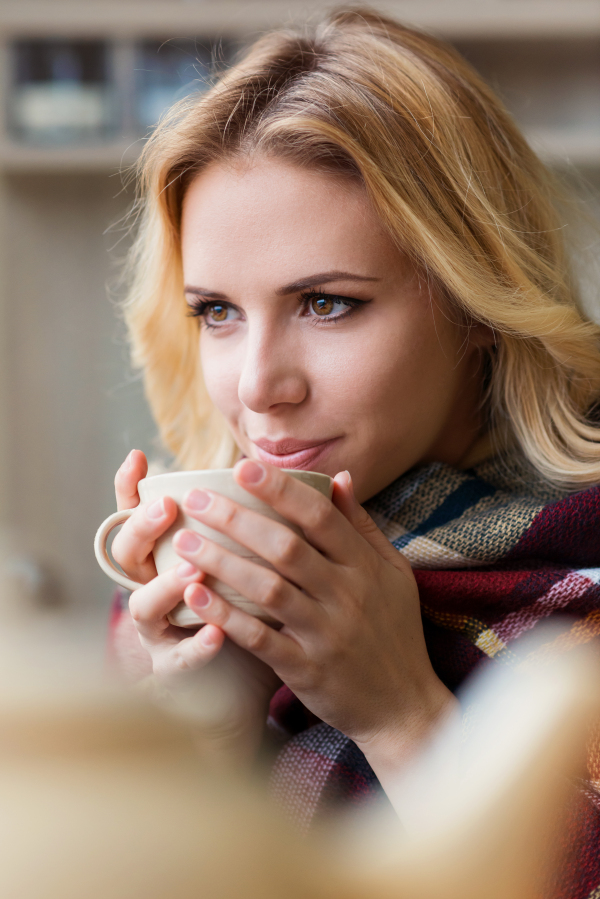 Beautiful woman relaxing at home with cup of coffee