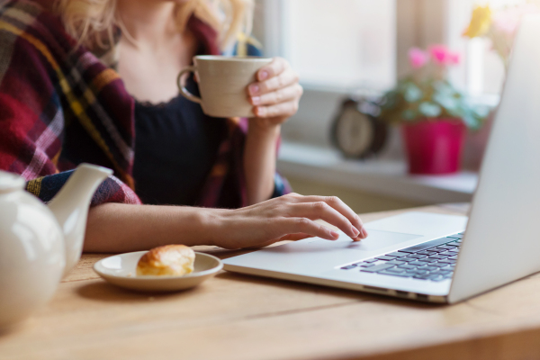 Beautiful woman relaxing at home with notebook and cup of coffee