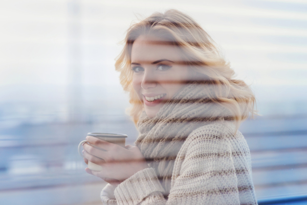 Beautiful woman relaxing at home with cup of coffee