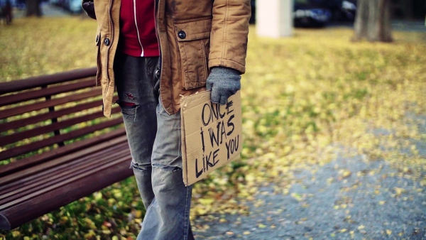 A midsection of portrait of homeless beggar man walking outdoors in park in autumn. Slow motion.