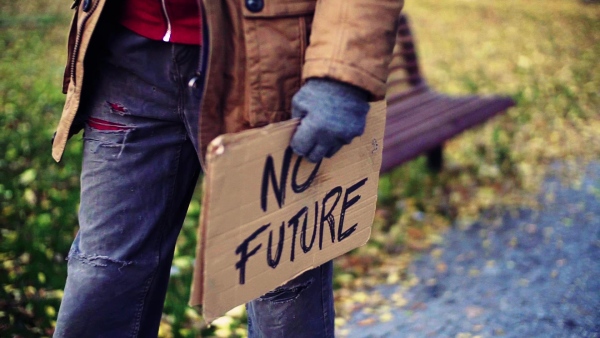 A midsection of portrait of homeless beggar man walking outdoors in park, carrying a cardboard sign. Slow motion.