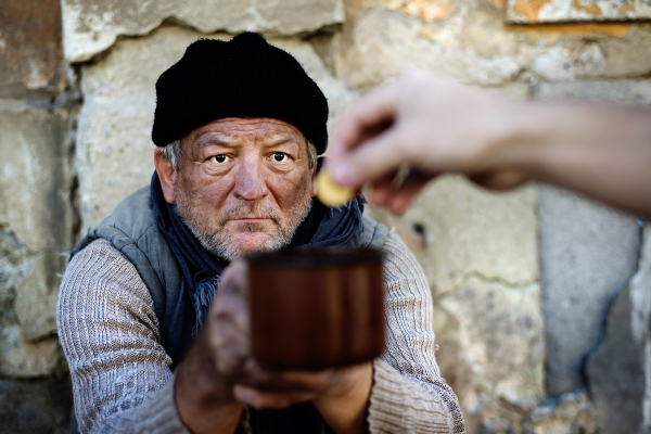 Homeless man begging for money on the street, feeling cold