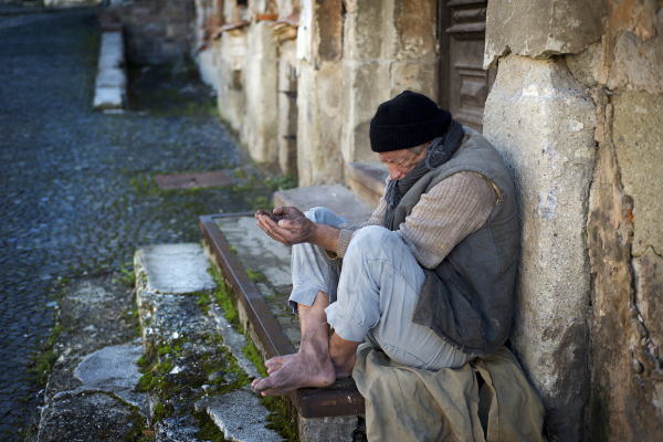 Homeless man in the street, sitting on stairs