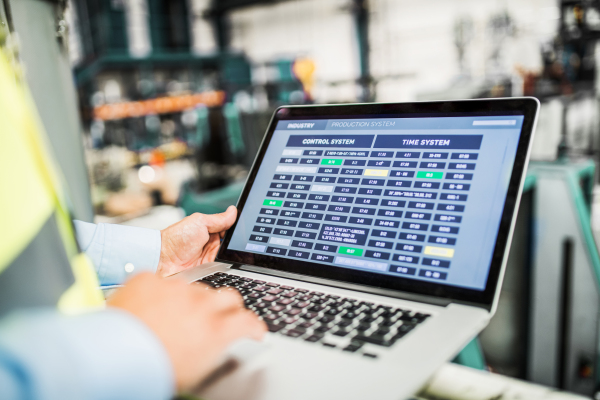 A midsection view of a mature industrial man engineer with laptop in a factory, working.