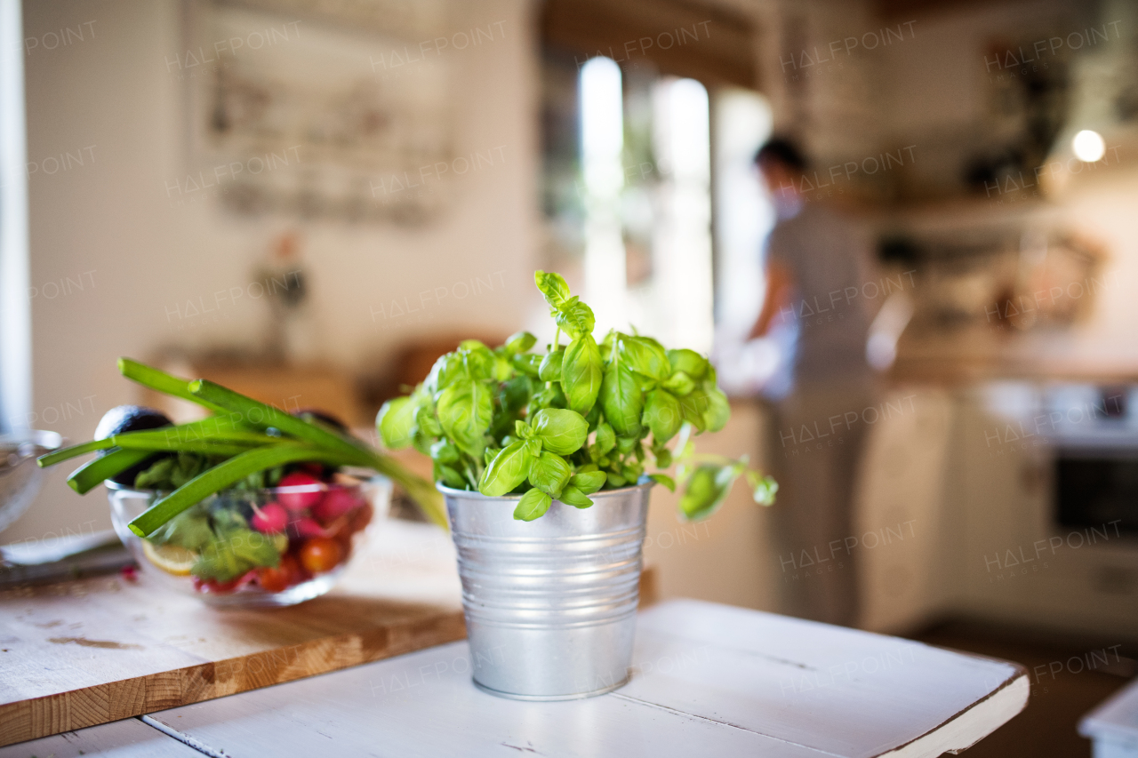 Fresh vegetables and herbs on the table in the kitchen.