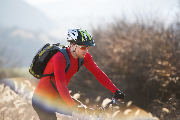 Young handsome man on the bicycle in the mountains.