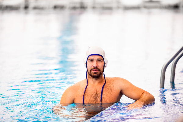 Water polo player in a swimming pool. Man doing sport.