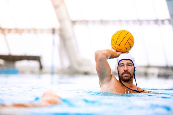 Water polo player in a swimming pool. Man doing sport.