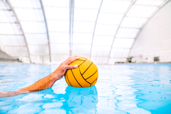 Unrecognizable water polo player in a swimming pool. Man doing sport.