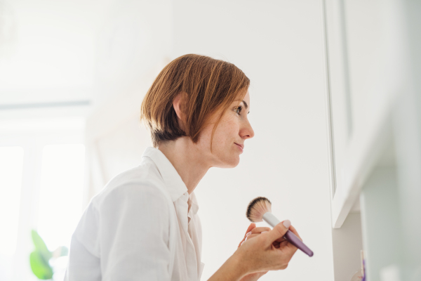 A morning routine of young woman putting on a make-up in a bathroom.