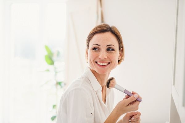 A morning routine of young woman putting on a make-up in a bathroom.