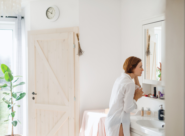 A morning routine of young woman putting on a make-up in a bathroom. Copy space.