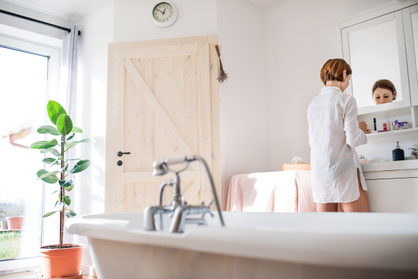 A morning routine of young woman putting on a make-up in a bathroom. Copy space.