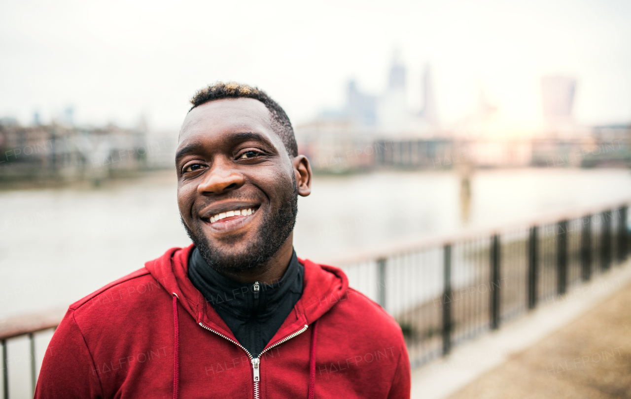 A close-up of black man runner standing in a city. Copy space.