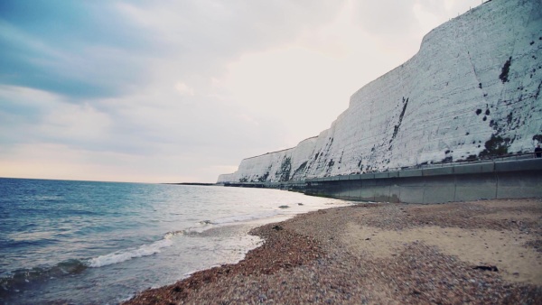 Sea and beach with chalk cliffs in Brighton, England. Slow motion.