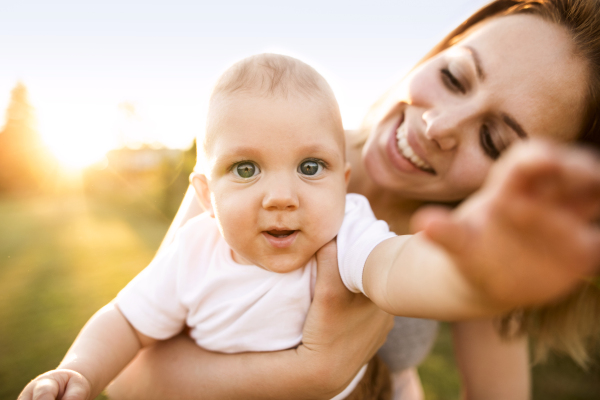 Beautiful young mother holding baby son in her arms.