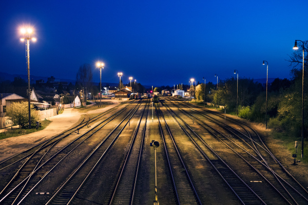 Railway tracks at train station. Railroad tracks near the depot under the night sky.