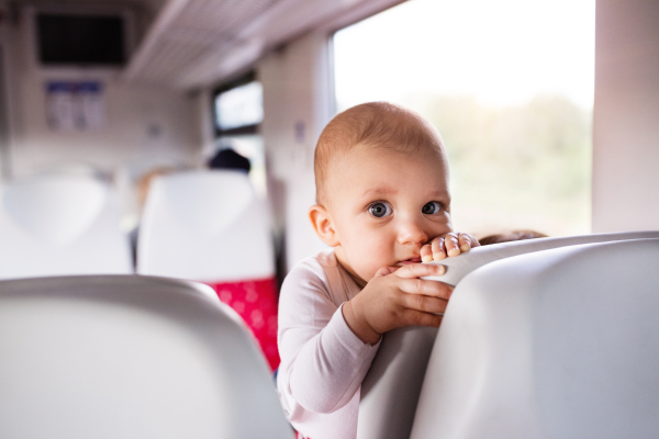 Cute baby boy travelling by train. Railway journey of a little infant boy.