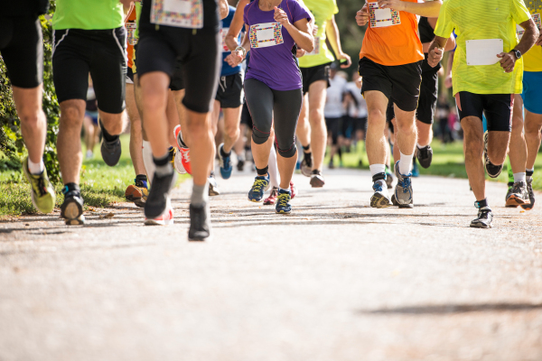 Group of unrecognizable runners sprinting outdoors. Sportive people training in a urban area, healthy lifestyle and sport concepts.