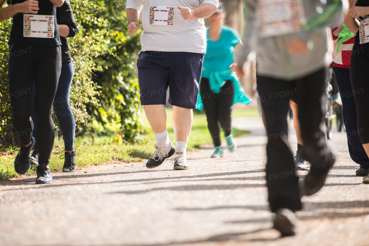 Group of unrecognizable runners sprinting outdoors. Sportive people training in a urban area. Healthy lifestyle and sport concepts.