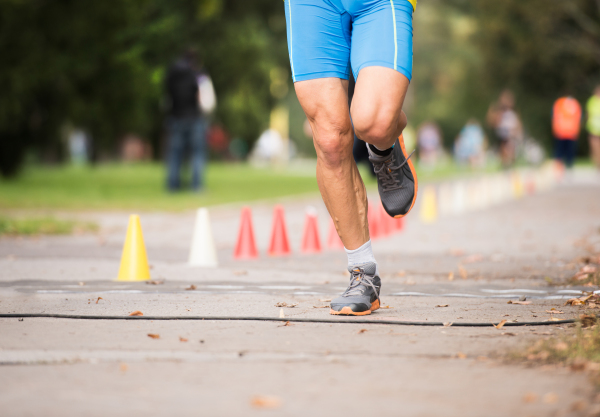 Unrecognizable runner sprinting outdoors. Sportive man training in a urban area, healthy lifestyle and sport concepts.