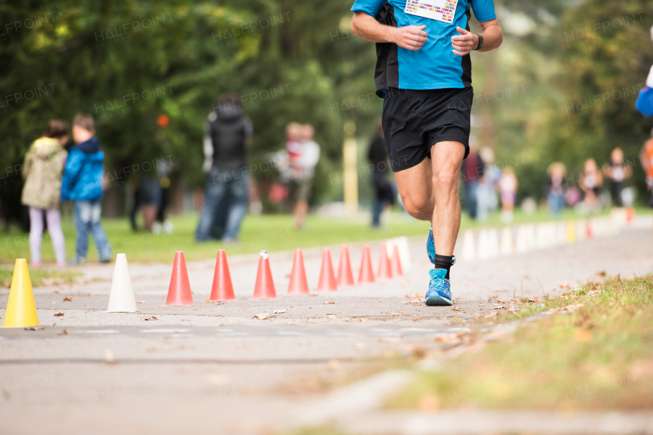 Unrecognizable runner sprinting outdoors. Sportive man training in a urban area, healthy lifestyle and sport concepts.