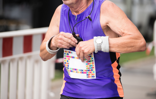 Unrecognizable senior runner outdoors. Sportive man competing in a urban area, healthy lifestyle and sport concepts.