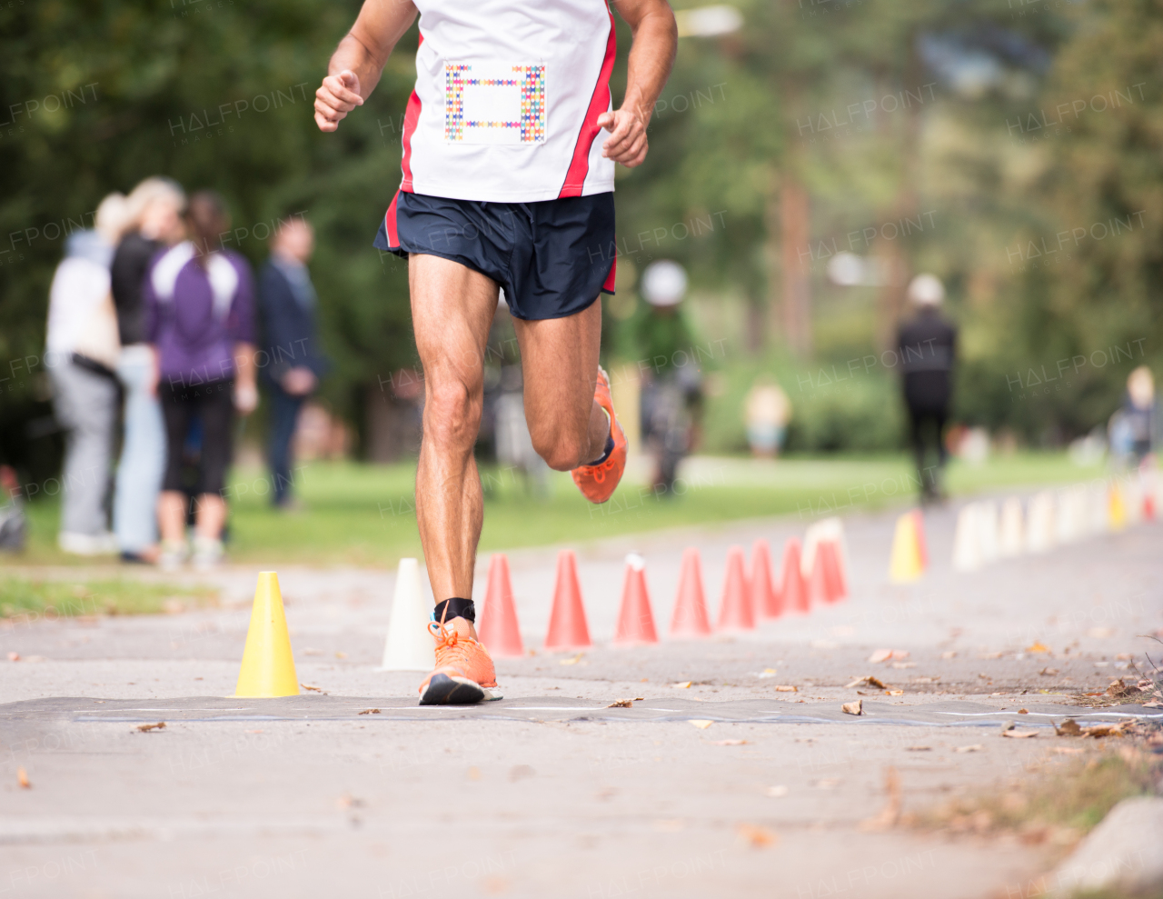 Unrecognizable runner sprinting outdoors. Sportive man competing in a urban area, healthy lifestyle and sport concepts.