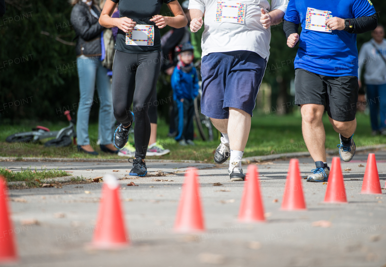 Group of unrecognizable runners jogging outdoors. Sportive people competing in a urban area, healthy lifestyle and sport concepts.