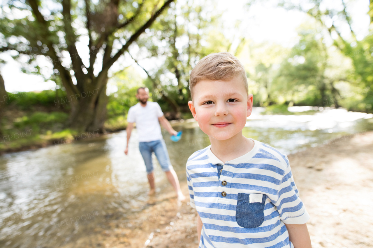 Little boy with his father at the river having fun, sunny spring day.