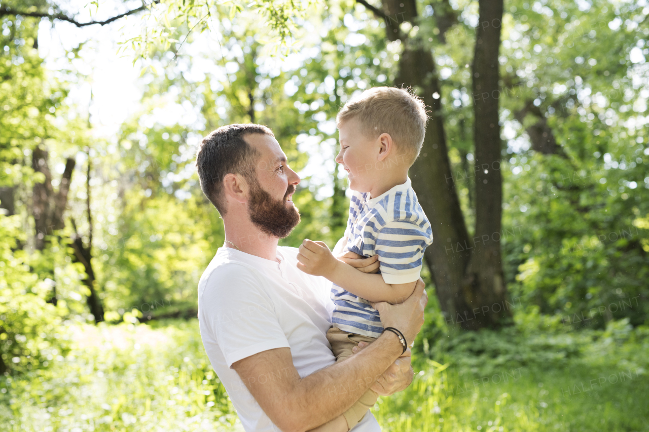 Young father with little boy putside having fun, sunny spring day.