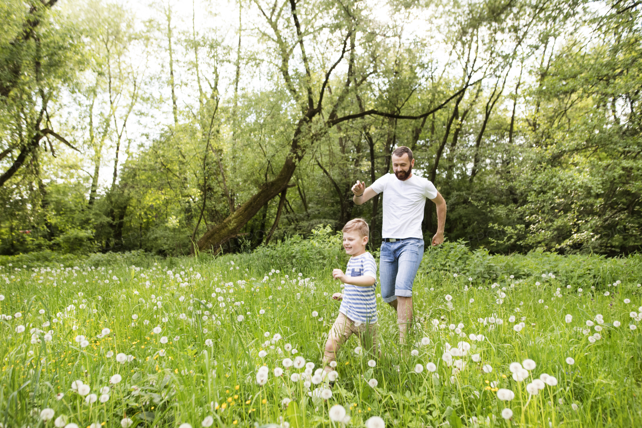 Young father with little boy outside having fun, sunny spring day.