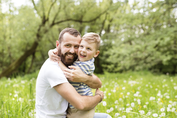 Young father with little boy outside having fun, sunny spring day.