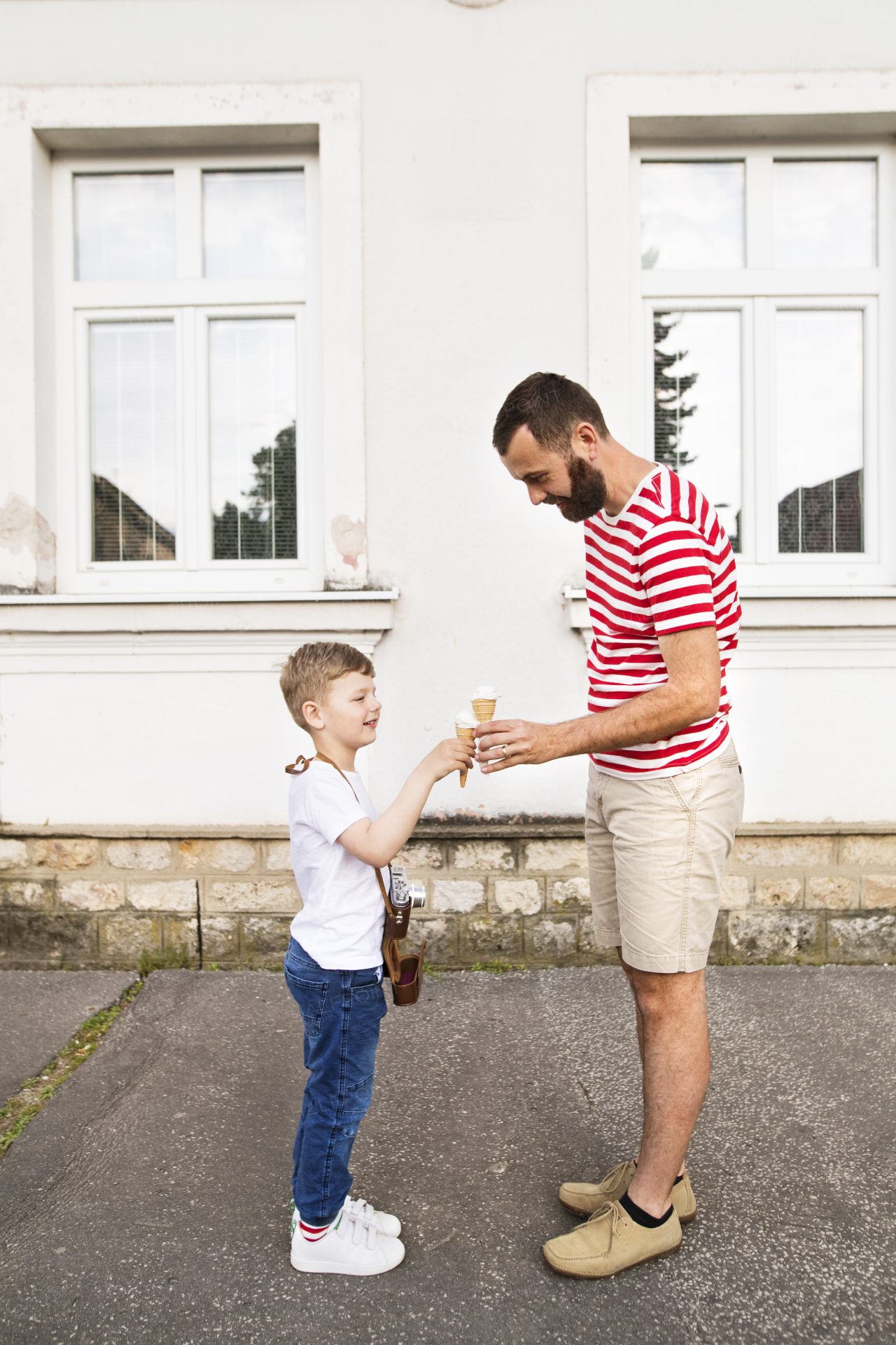 Young father and his little son eating ice cream. Sunny summer day.