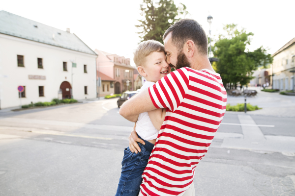 Young father with little boy outside having fun, sunny spring day.