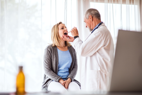 Senior doctor examining a young woman. A doctor and a patient at the doctors office.