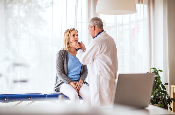 Senior doctor examining a young woman. A doctor and a patient at the doctors office.