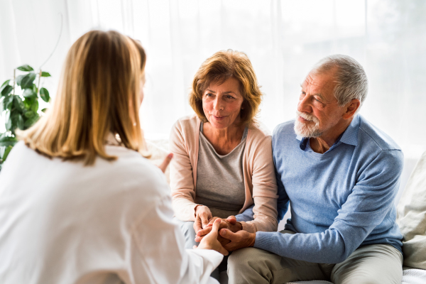 Young female doctor talking to a senior couple.