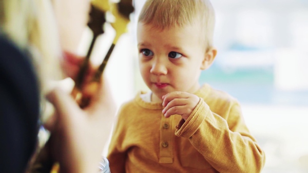 A small toddler boy with his mother eating biscuit in zero waste shop. Slow motion.