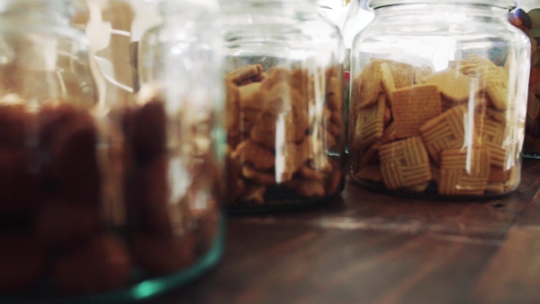 An extreme close-up of jars with biscuits on a table in zero waste shop. Slow motion.